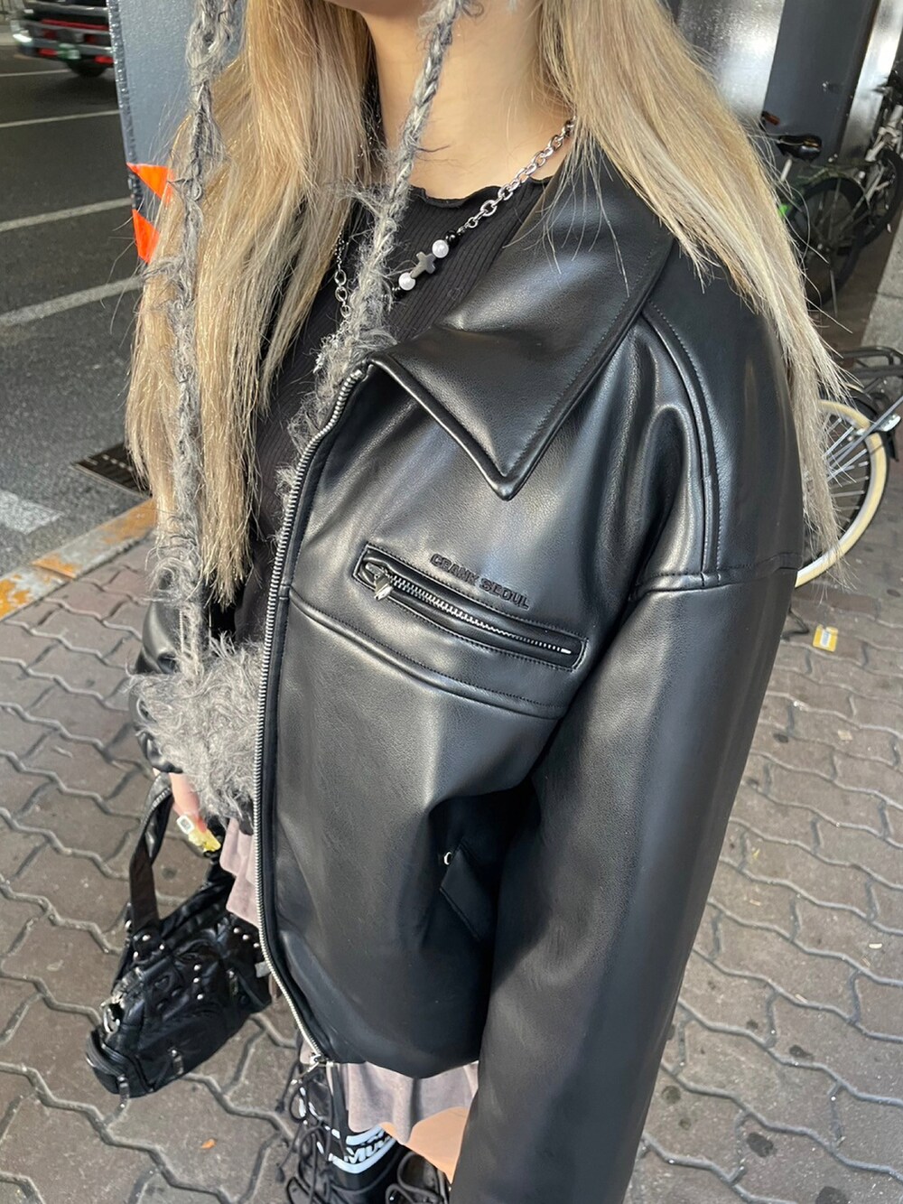 ブラック系のブルゾン、ブラック系のカーディガン/ボレロ、ブラック系のハンドバッグを着用したレディースの冬コーディネートの5枚目の写真