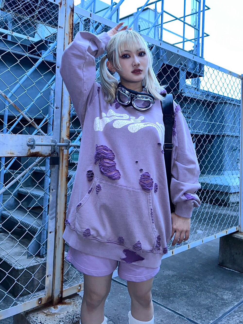 パープル系のパーカー、ブラック系のショルダーバッグを着用したレディースの秋コーディネートの2枚目の写真