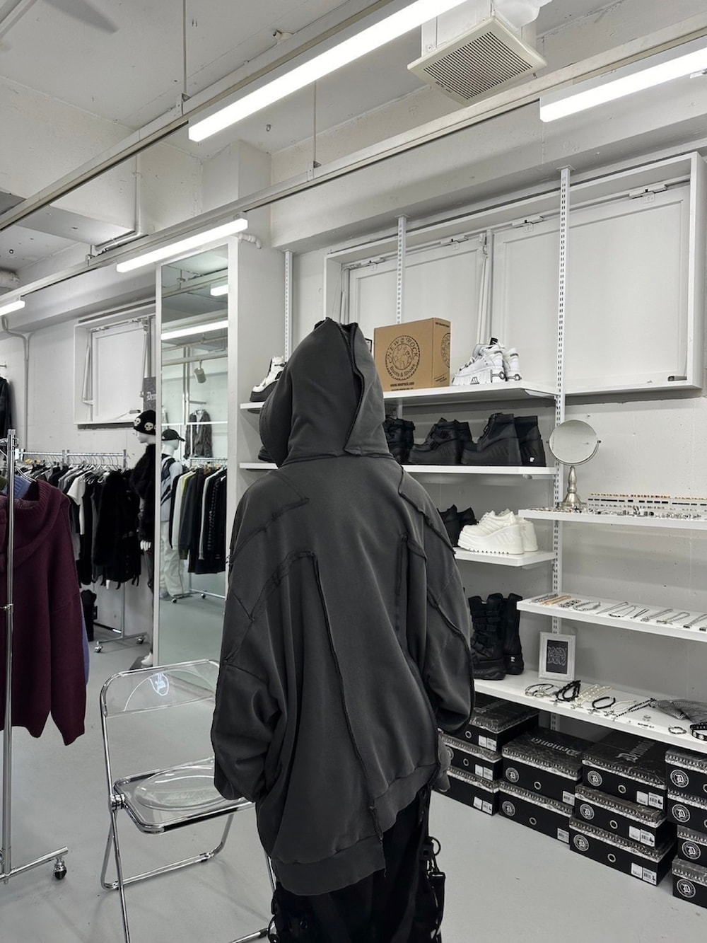 グレー系のパーカー、ブラック系のデニムパンツを着用したメンズの春コーディネートの3枚目の写真