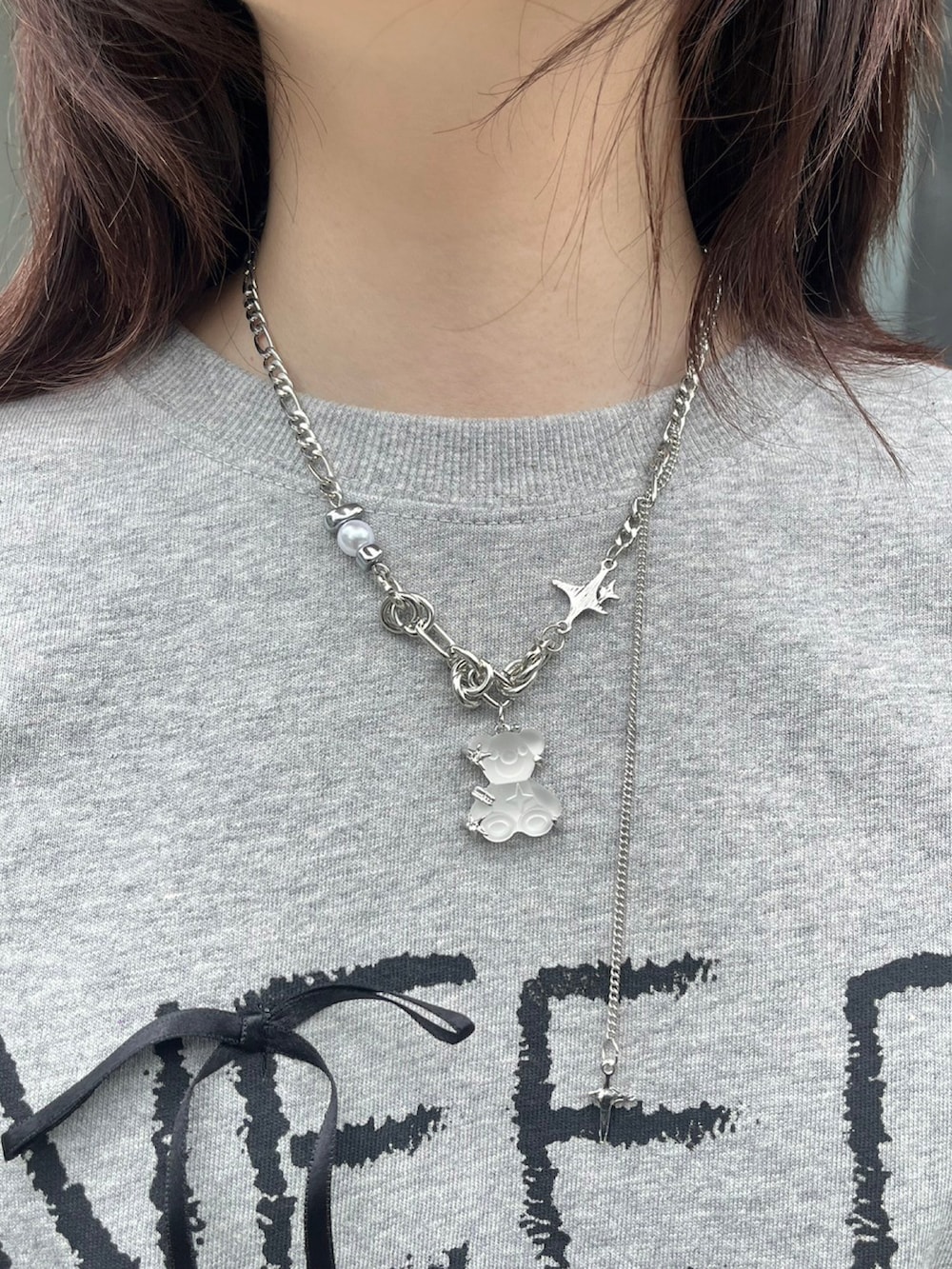 ホワイト系のショルダーバッグ、ホワイト系のキャップ、シルバー系のネックレスを着用したレディースの春コーディネートの5枚目の写真