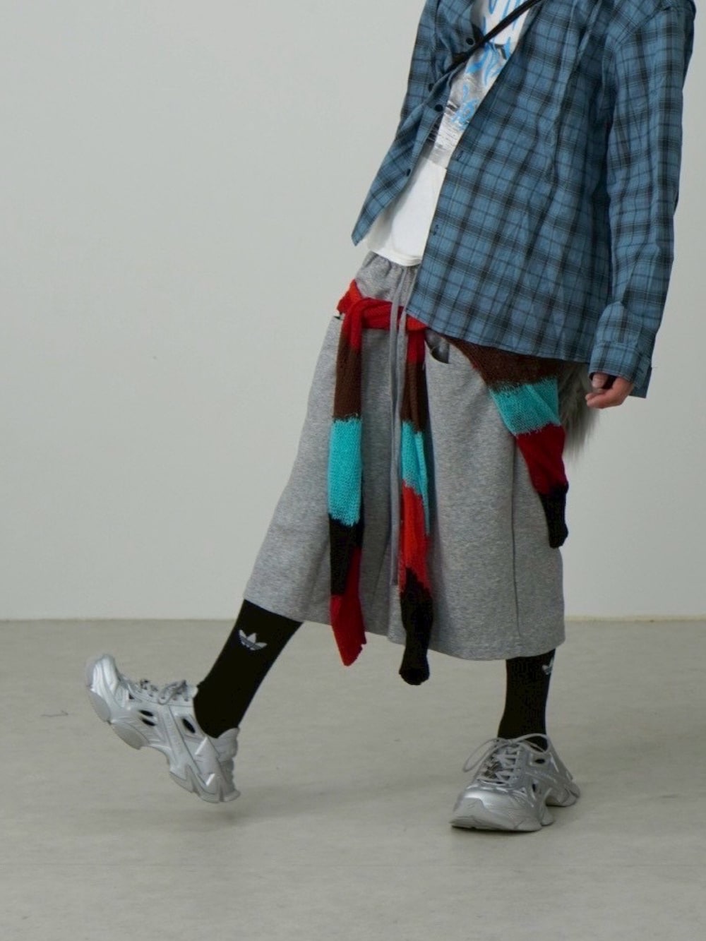 グレー系のショルダーバッグ、シルバー系のサンダル、グレー系のスウェットパンツを着用したメンズの夏コーディネートの3枚目の写真