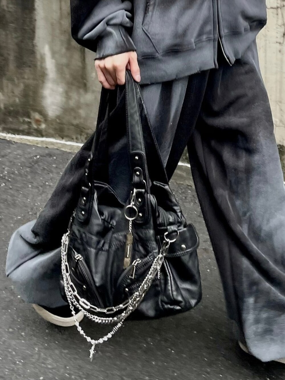 ブラック系のショルダーバッグ、ブラック系のパーカー、ブラック系のスウェットパンツを着用したメンズの秋コーディネートの5枚目の写真