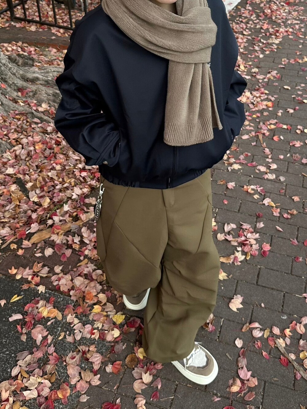 ブラウン系のスラックス、ブラウン系のマフラーを着用したレディースの冬コーディネートの5枚目の写真