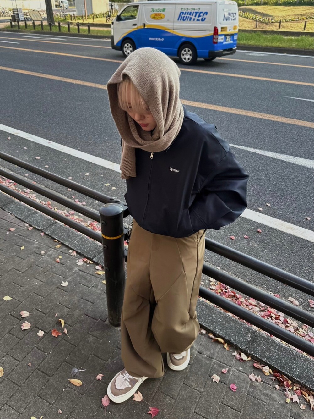 ブラウン系のスラックス、ブラウン系のマフラーを着用したレディースの冬コーディネートの2枚目の写真