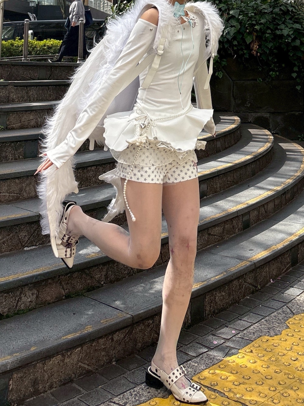 ホワイト系のバックパック/リュック、ホワイト系のその他パンツ、ベージュ系のタイツ/ストッキングを着用したレディースの春コーディネートの3枚目の写真