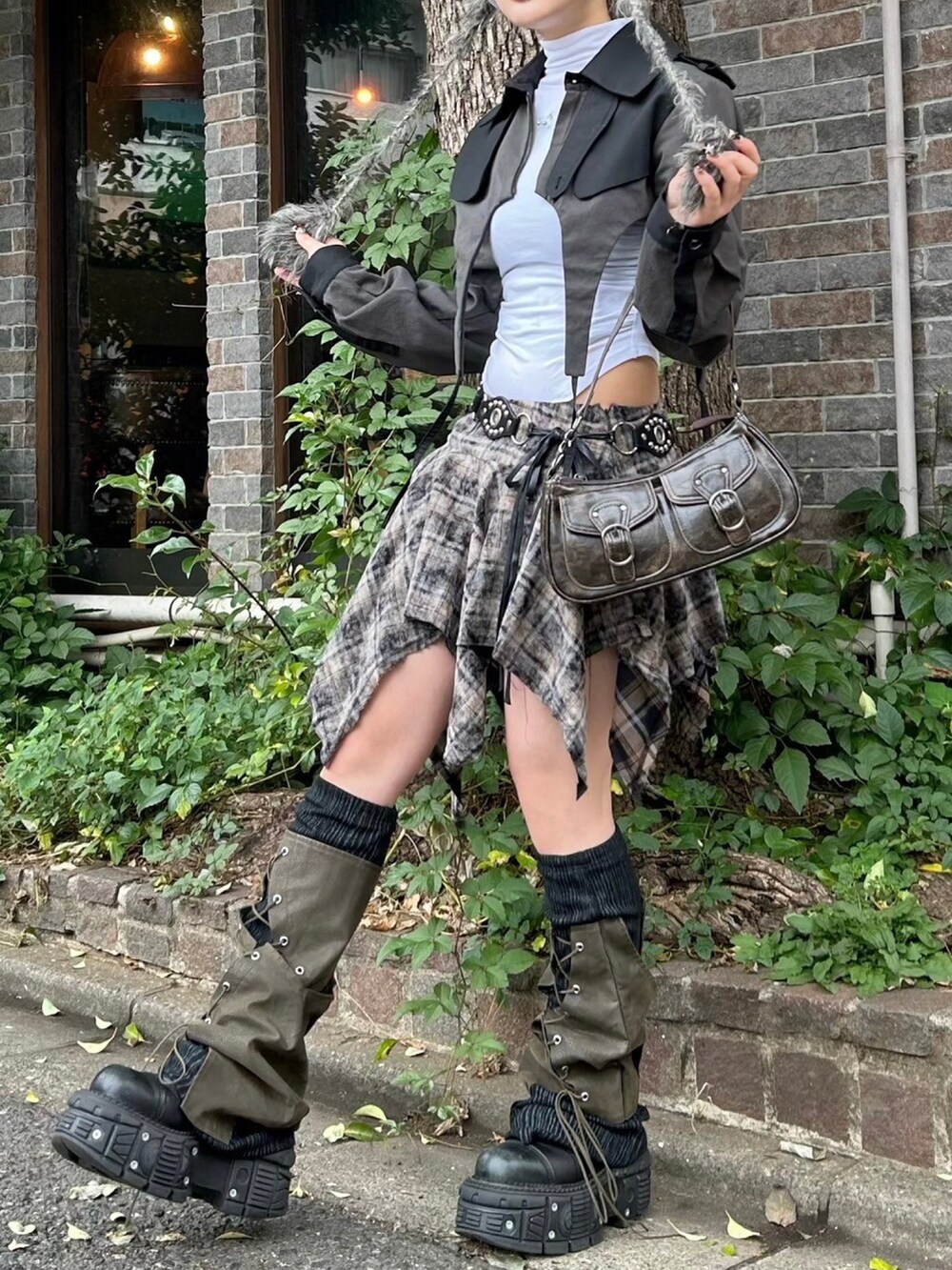 ブラウン系のショルダーバッグ、ブラック系のトレンチコート、グレー系のニットキャップ/ビーニーを着用したレディースの秋コーディネートの2枚目の写真