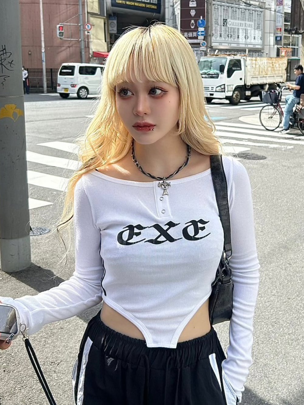 ホワイト系のTシャツ/カットソー、ブラック系のショルダーバッグ、ブラック系のカーゴパンツを着用したレディースの秋コーディネートの4枚目の写真