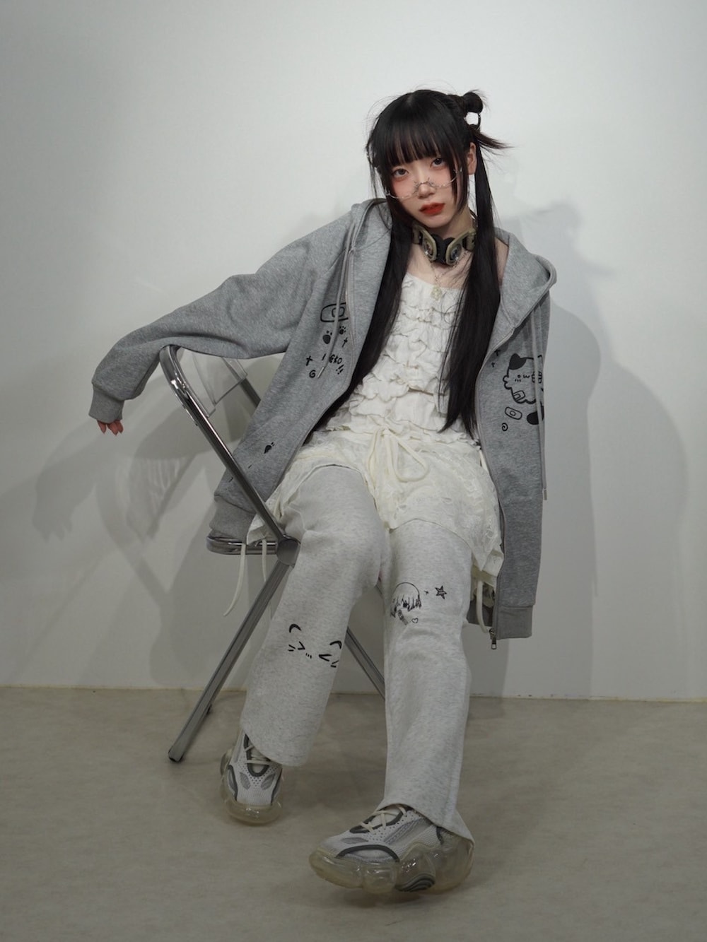 グレー系のパーカー、シルバー系のメガネを着用したレディースの秋コーディネートの2枚目の写真