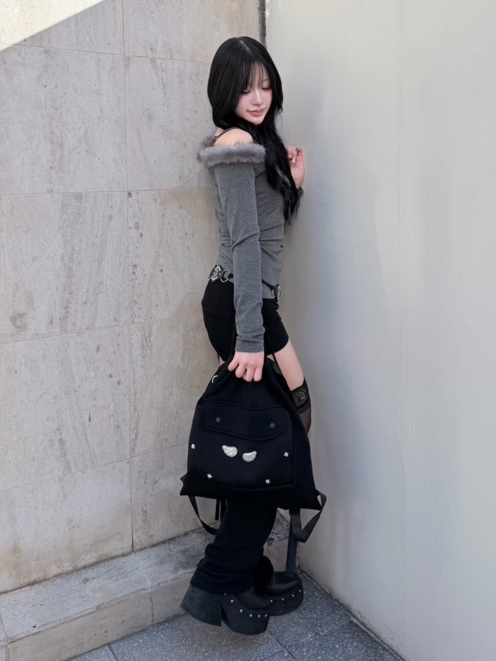 ブラック系のバックパック/リュック、グレー系のTシャツ/カットソー、ブラック系のネックレスを着用したレディースの冬コーディネートの2枚目の写真