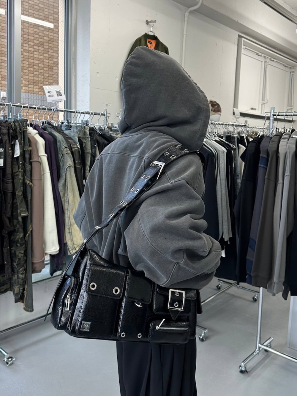 ブラック系のニット/セーター、グレー系のパーカーを着用したメンズの冬コーディネートの3枚目の写真