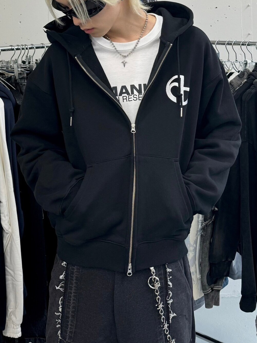 ホワイト系のショルダーバッグ、ブラック系のデニムパンツ、ブラック系のパーカーを着用したメンズの冬コーディネートの3枚目の写真