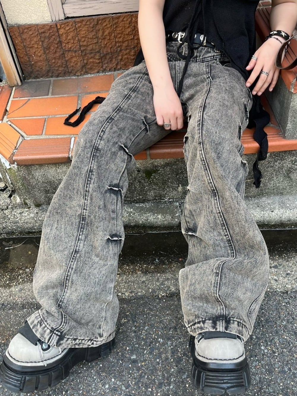 ベージュ系のデニムパンツ、ブラック系のチューブトップ、ブラウン系のショルダーバッグを着用したレディースの夏コーディネートの2枚目の写真