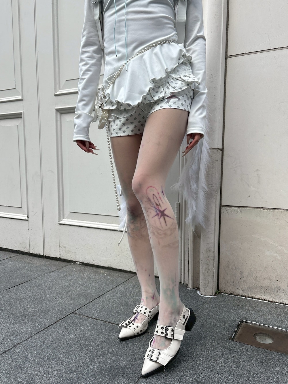 ホワイト系のバックパック/リュック、ホワイト系のその他パンツ、ベージュ系のタイツ/ストッキングを着用したレディースの春コーディネートの4枚目の写真