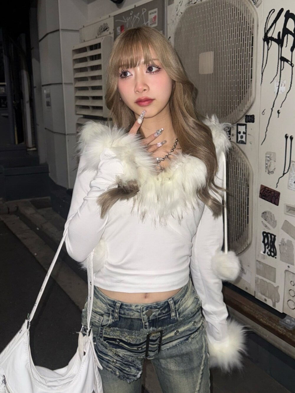 ホワイト系のショルダーバッグ、ブラック系のキーホルダーを着用したレディースの冬コーディネートの2枚目の写真