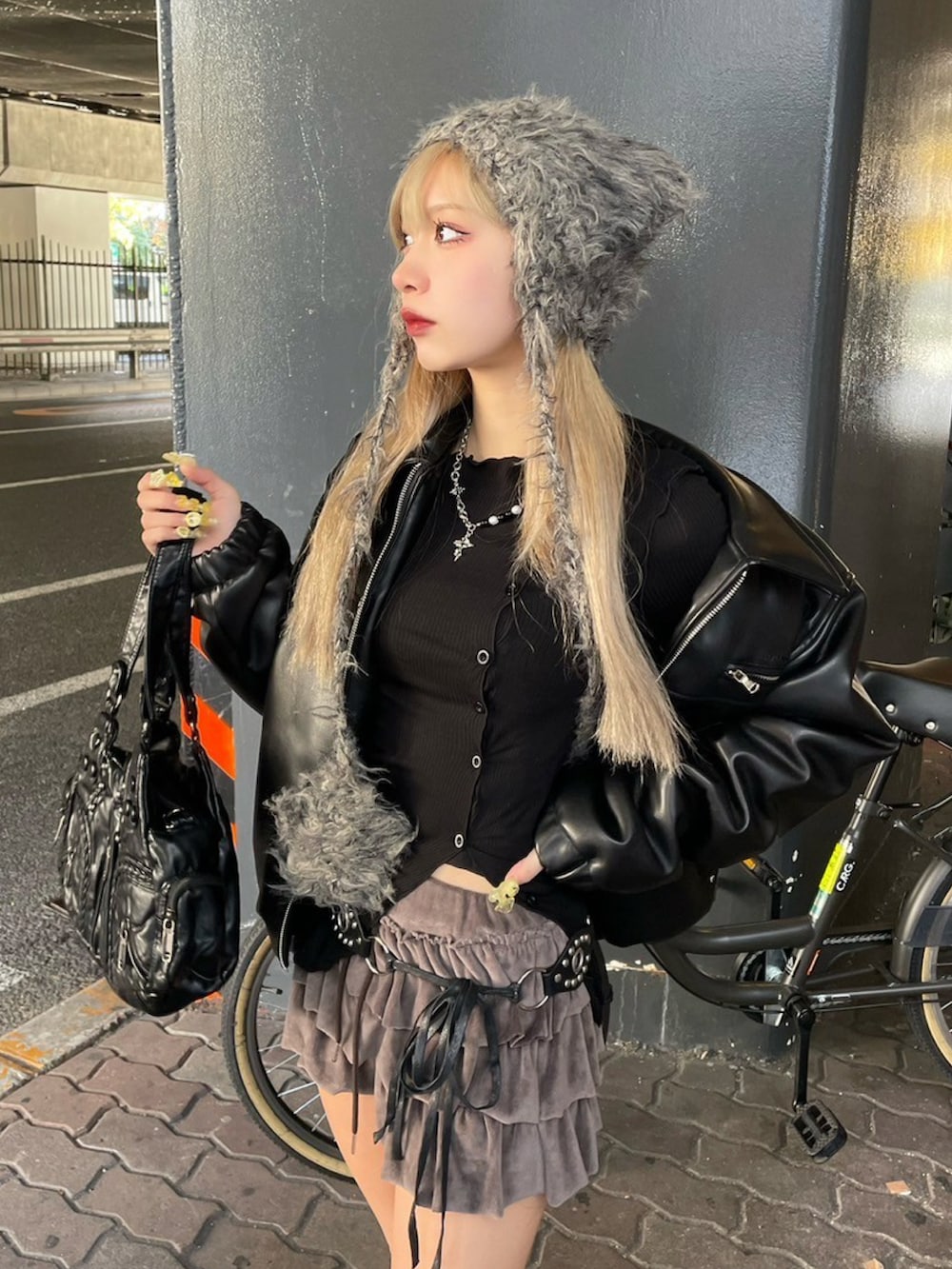 ブラック系のブルゾン、ブラック系のカーディガン/ボレロ、ブラック系のハンドバッグを着用したレディースの冬コーディネートの3枚目の写真