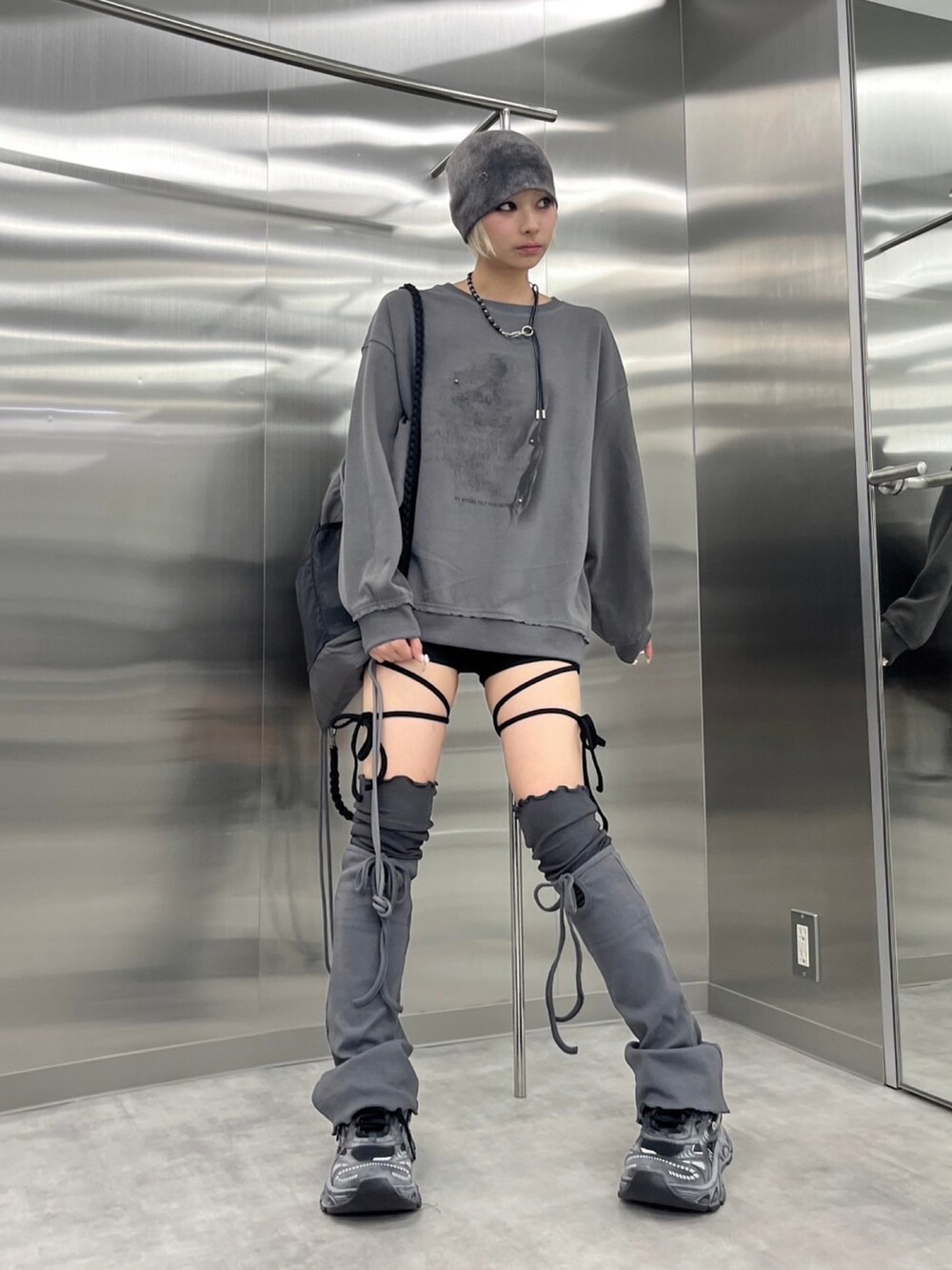 グレー系のスウェット、ブラック系のバックパック/リュック、パープル系のニットキャップ/ビーニーを着用したレディースの秋コーディネートの5枚目の写真