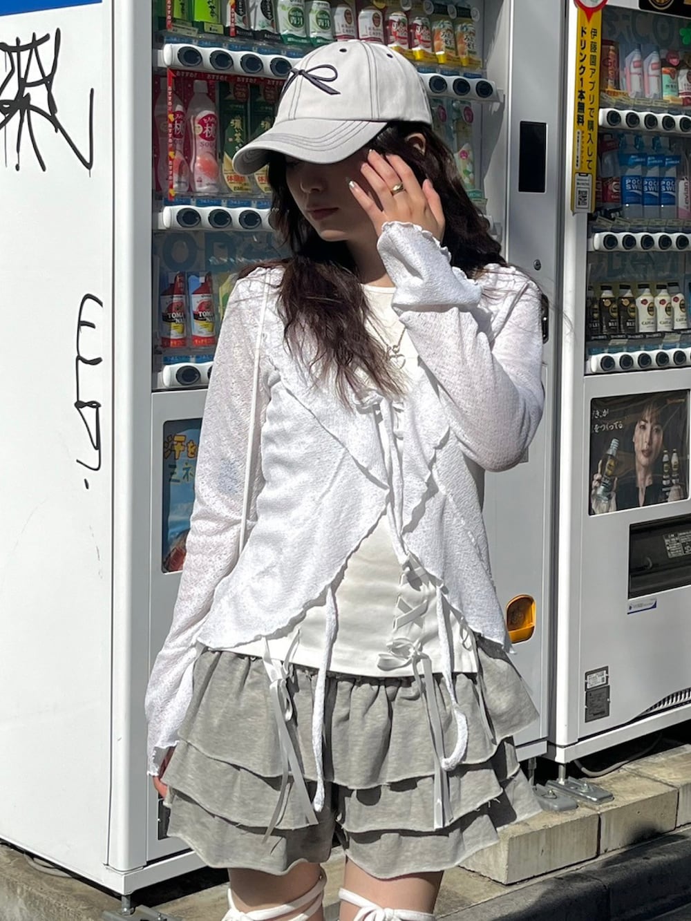 ホワイト系のタンクトップ、グレー系のスカート、ホワイト系のバックパック/リュックを着用したレディースの春コーディネートの3枚目の写真