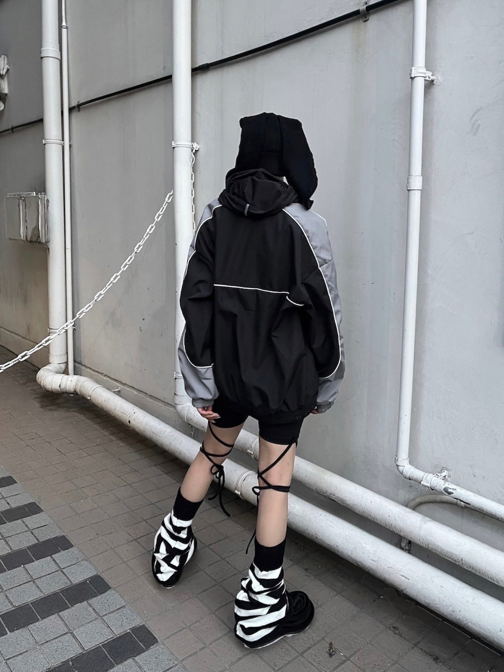 ブラック系のスニーカー、ブラック系のブルゾン、ブラック系のニットキャップ/ビーニーを着用したレディースの秋コーディネートの2枚目の写真