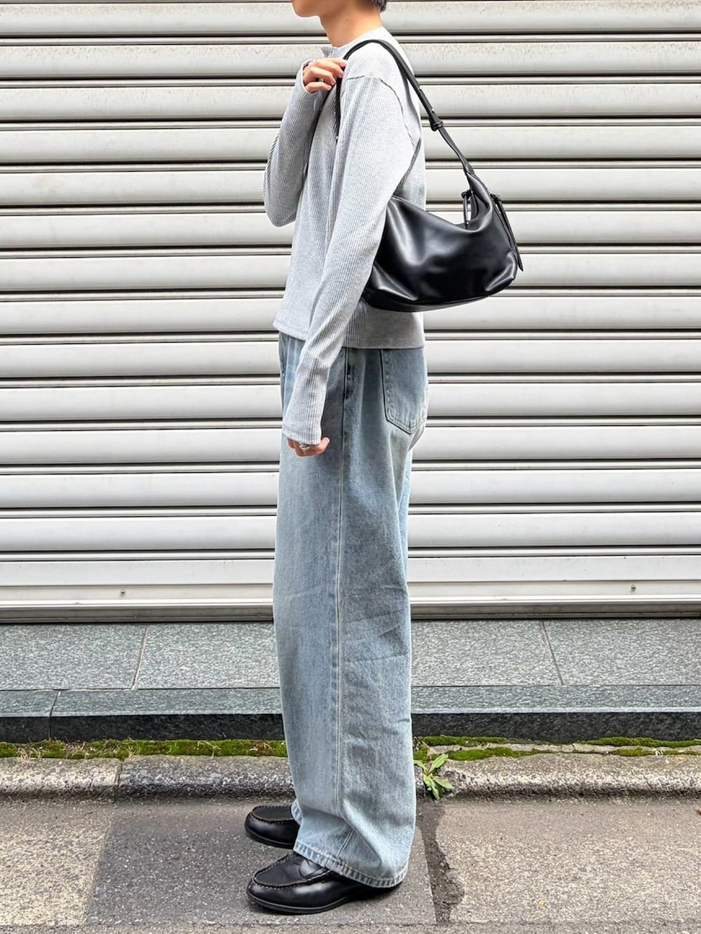 グレー系のTシャツ/カットソー、ブラック系のショルダーバッグ、ブルー系のデニムパンツを着用したメンズの秋コーディネートの3枚目の写真