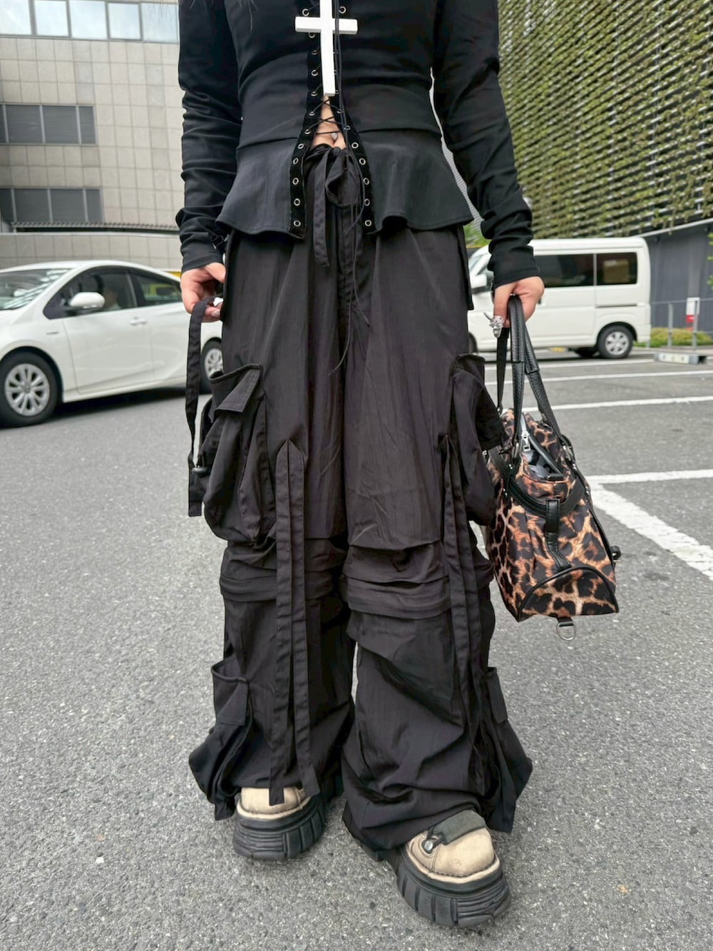 ブラウン系のショルダーバッグ、ブラック系のカーゴパンツ、ホワイト系のネックレスを着用したレディースの夏コーディネートの5枚目の写真