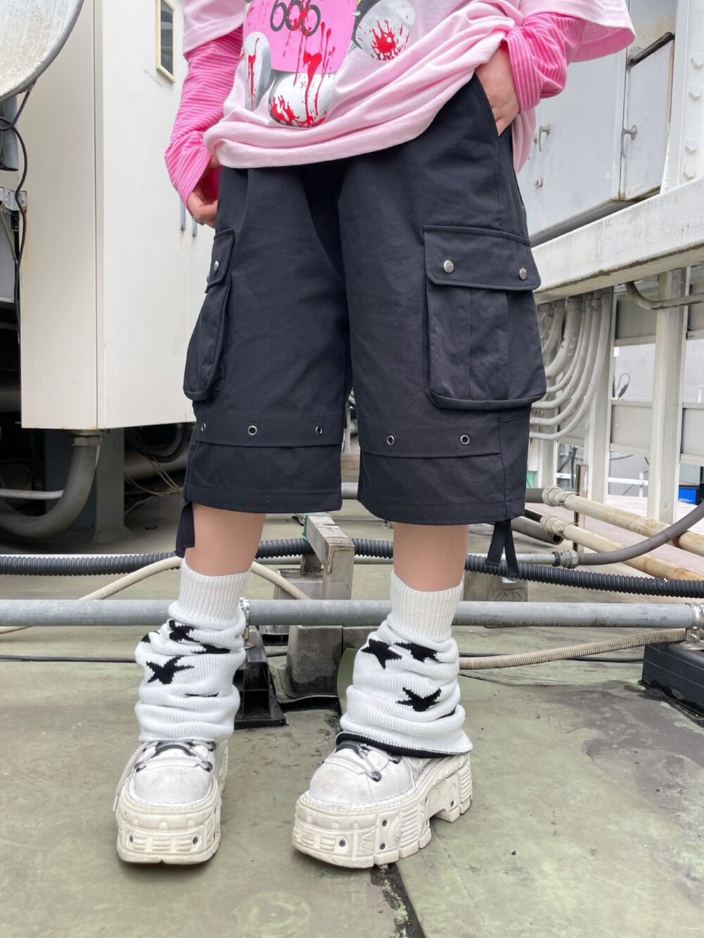 ピンク系のハンドバッグ、ブラック系のカーゴパンツ、ホワイト系のレッグウォーマーを着用したレディースの春コーディネートの2枚目の写真