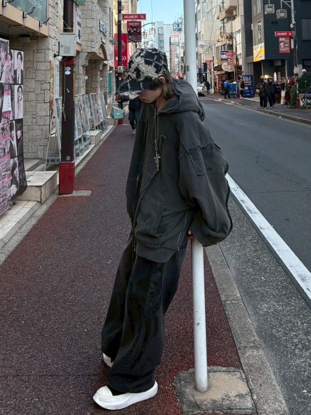 ブラック系のデニムパンツ、グレー系のパーカーを着用したメンズの冬コーディネートの4枚目の写真