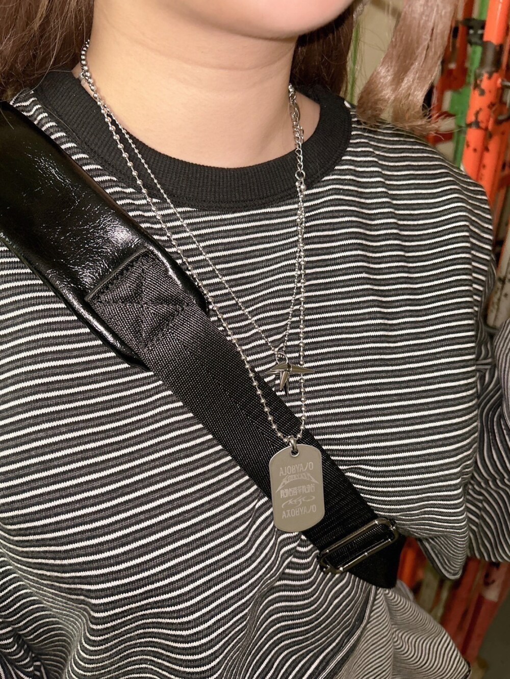 ブラック系のTシャツ/カットソー、ブラック系のデニムパンツ、ブラック系のショルダーバッグを着用したレディースの冬コーディネートの2枚目の写真