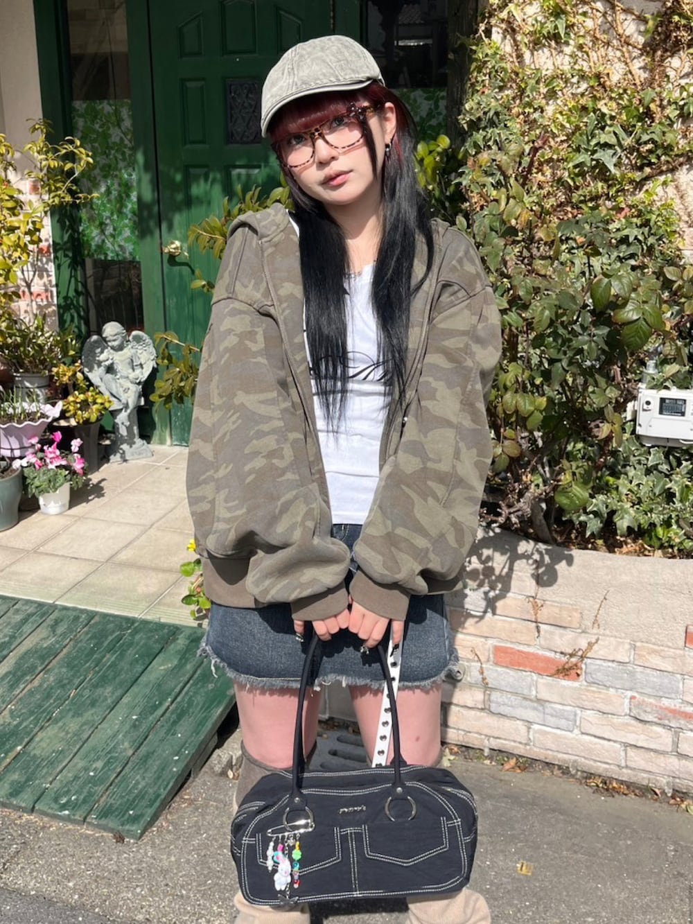 ホワイト系のTシャツ/カットソー、ブラック系のハンドバッグ、ベージュ系のレッグウォーマーを着用したレディースの冬コーディネートの2枚目の写真