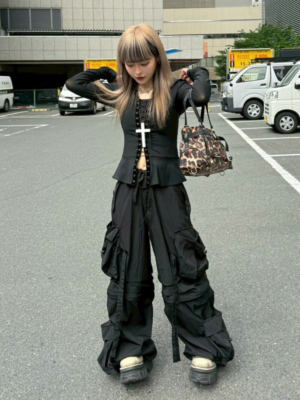 ブラウン系のショルダーバッグ、ブラック系のカーゴパンツ、ホワイト系のネックレスを着用したレディースの夏コーディネートの2枚目の写真