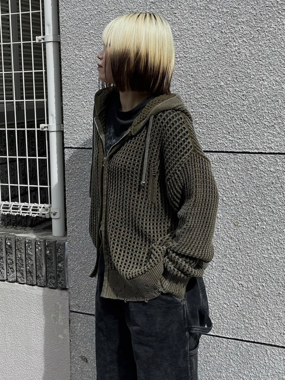 グリーン系のパーカーを着用したレディースの秋コーディネートの3枚目の写真