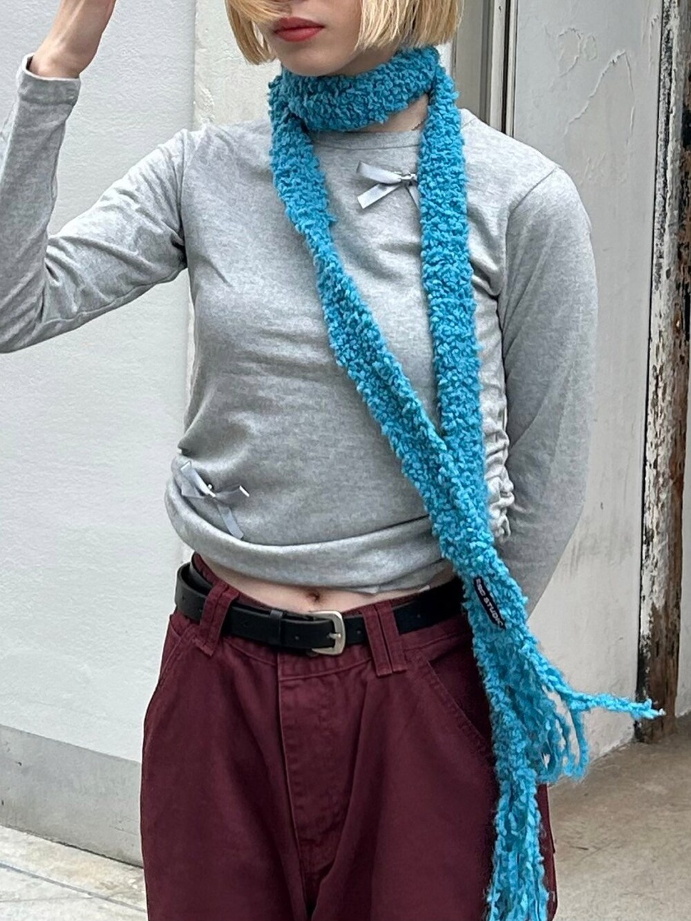 レッド系のデニムパンツを着用したレディースの秋コーディネートの3枚目の写真