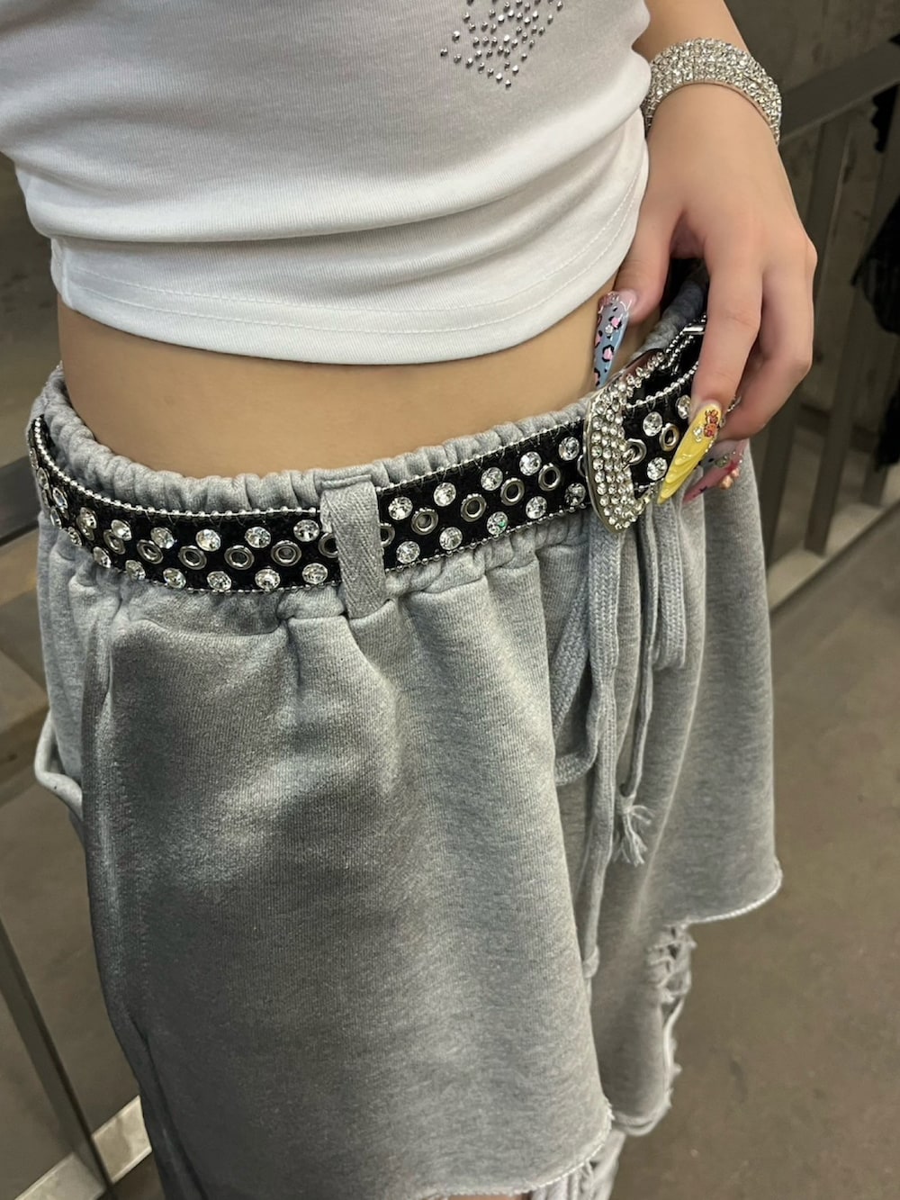 グレー系のスウェットパンツ、ホワイト系のキャミソール、シルバー系のネックレスを着用したレディースの夏コーディネートの5枚目の写真