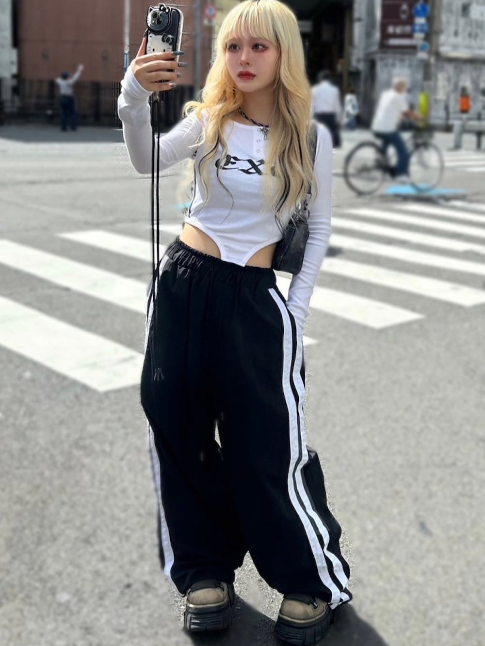 ホワイト系のTシャツ/カットソー、ブラック系のショルダーバッグ、ブラック系のカーゴパンツを着用したレディースの秋コーディネートの3枚目の写真