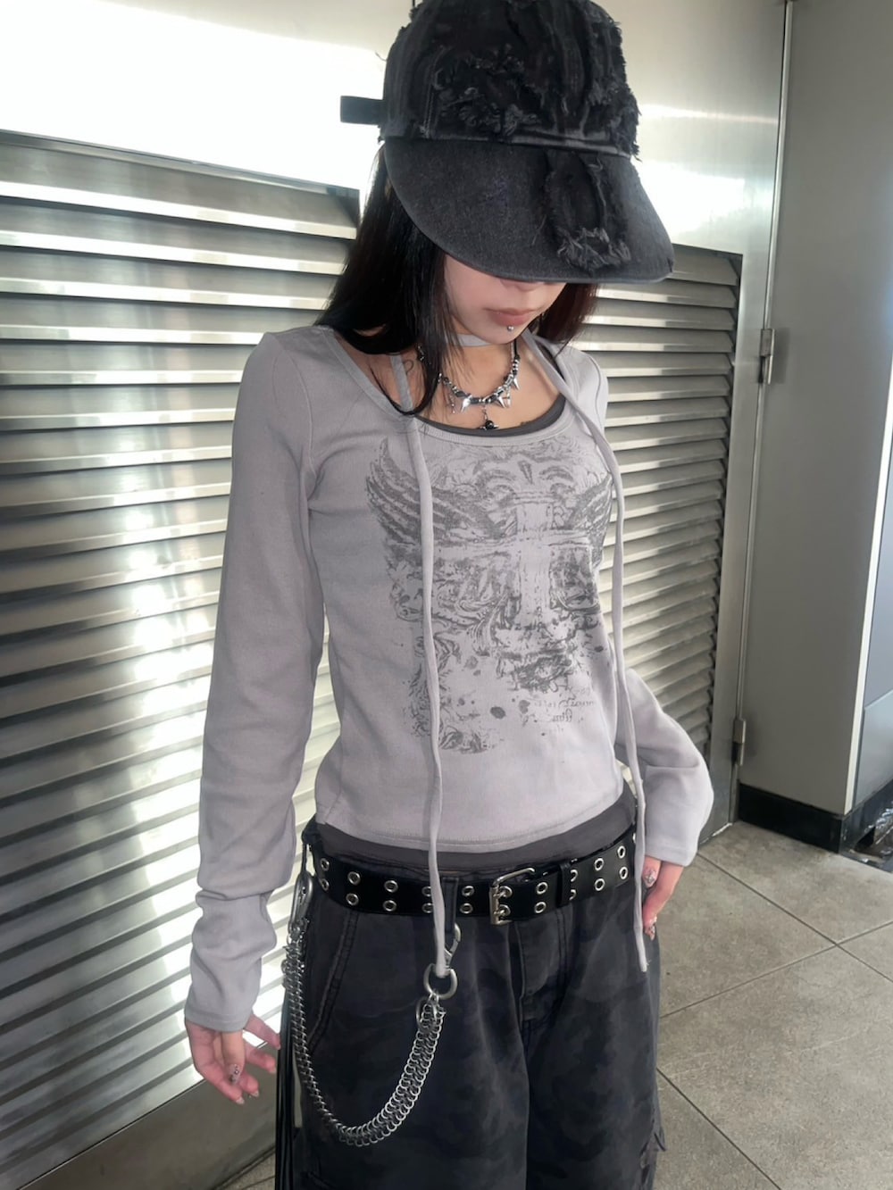 グレー系のTシャツ/カットソー、ブラック系のデニムパンツ、ホワイト系のスニーカーを着用したレディースの春コーディネートの3枚目の写真