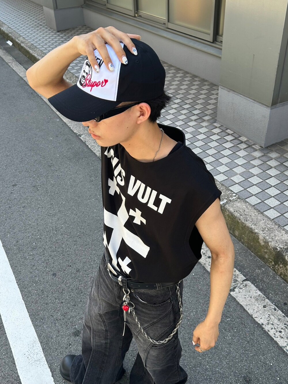 ブラック系のデニムパンツ、ブラック系のスリッポン、ブラック系のキャップを着用したメンズの夏コーディネートの2枚目の写真