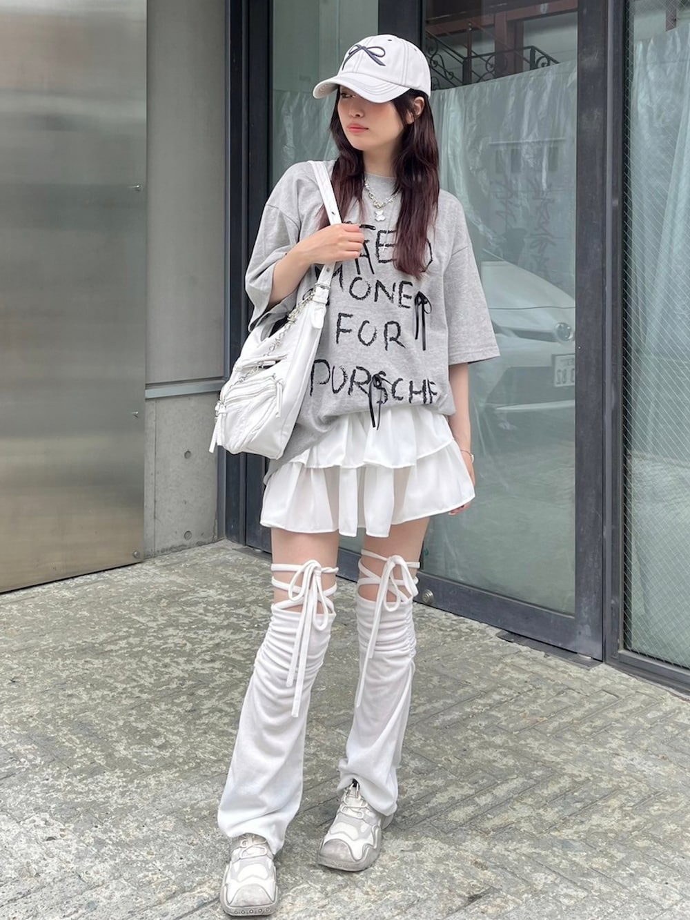 ホワイト系のショルダーバッグ、ホワイト系のキャップ、シルバー系のネックレスを着用したレディースの春コーディネートの2枚目の写真