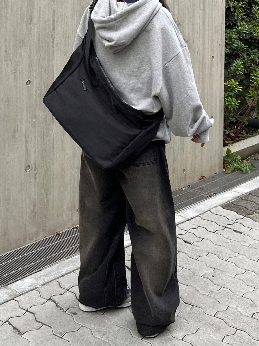 ブラック系のデニムパンツ、ブラック系のショルダーバッグを着用したレディースの冬コーディネートの2枚目の写真