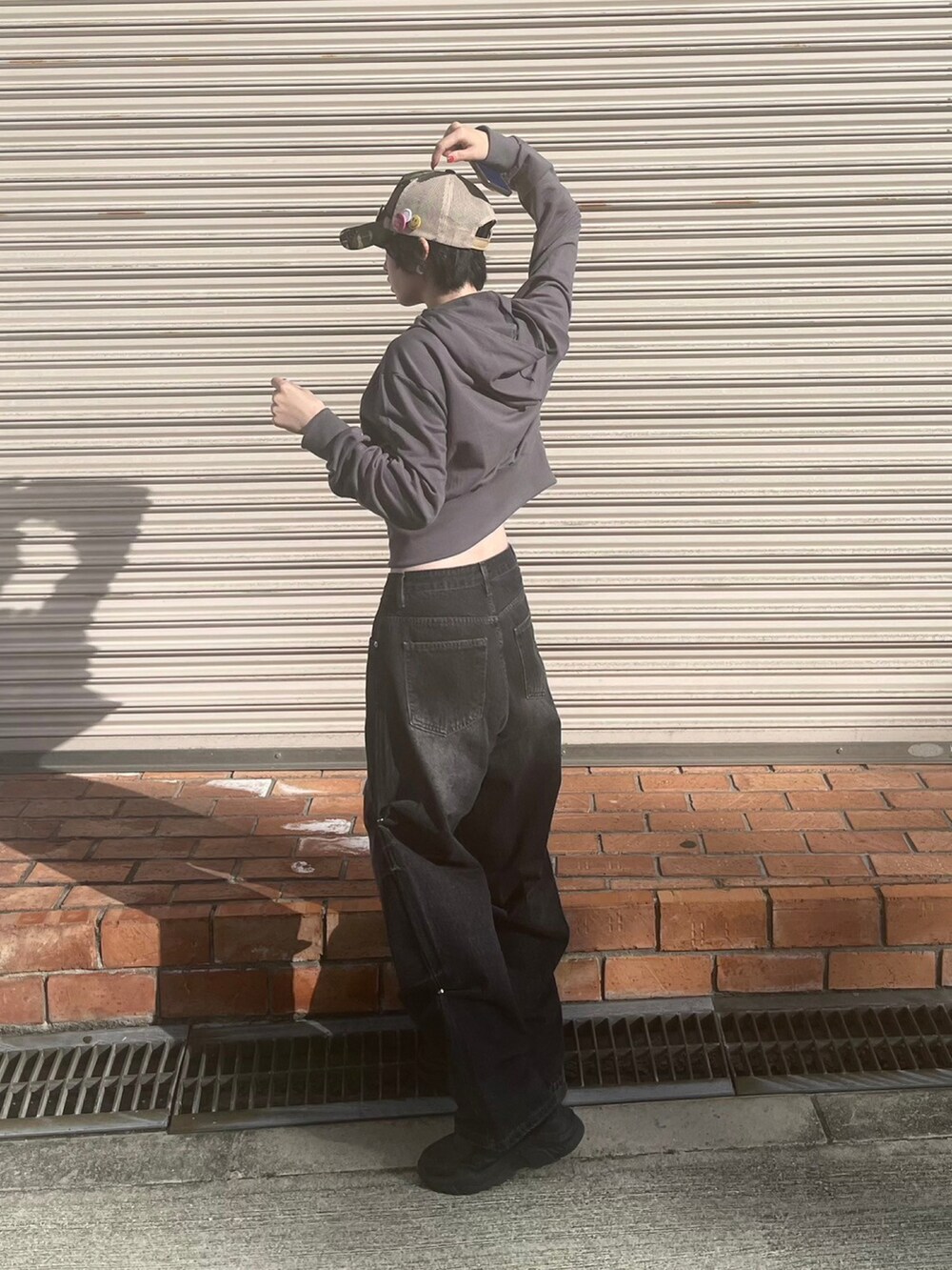 ブラック系のデニムパンツ、その他のキャップを着用したレディースの秋コーディネートの2枚目の写真