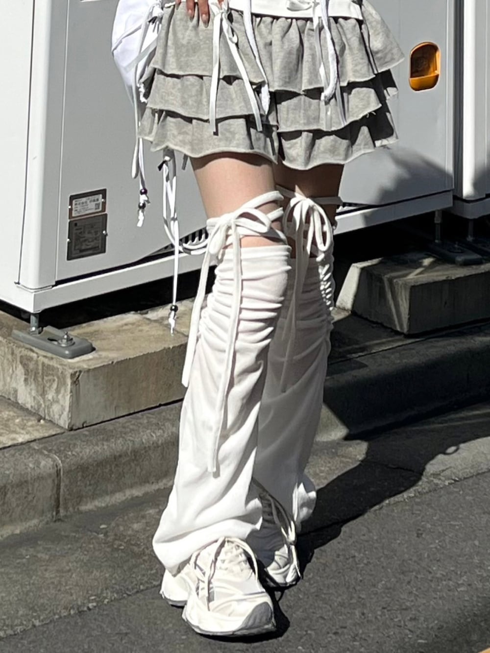 ホワイト系のタンクトップ、グレー系のスカート、ホワイト系のバックパック/リュックを着用したレディースの春コーディネートの4枚目の写真