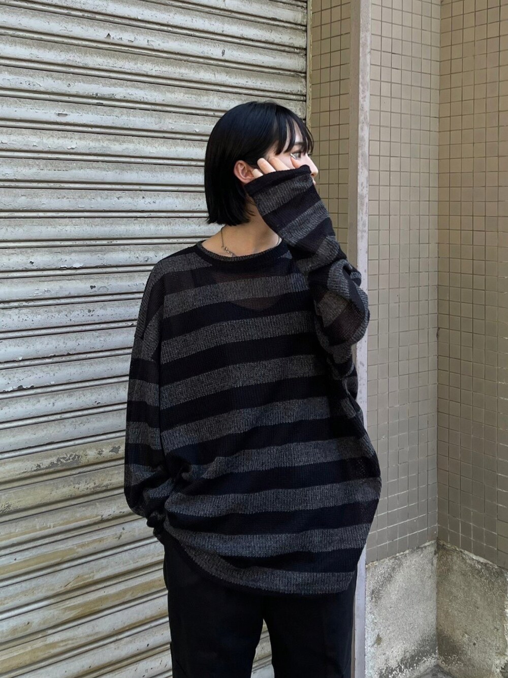 ブラック系のニット/セーターを着用したレディースの秋コーディネートの2枚目の写真