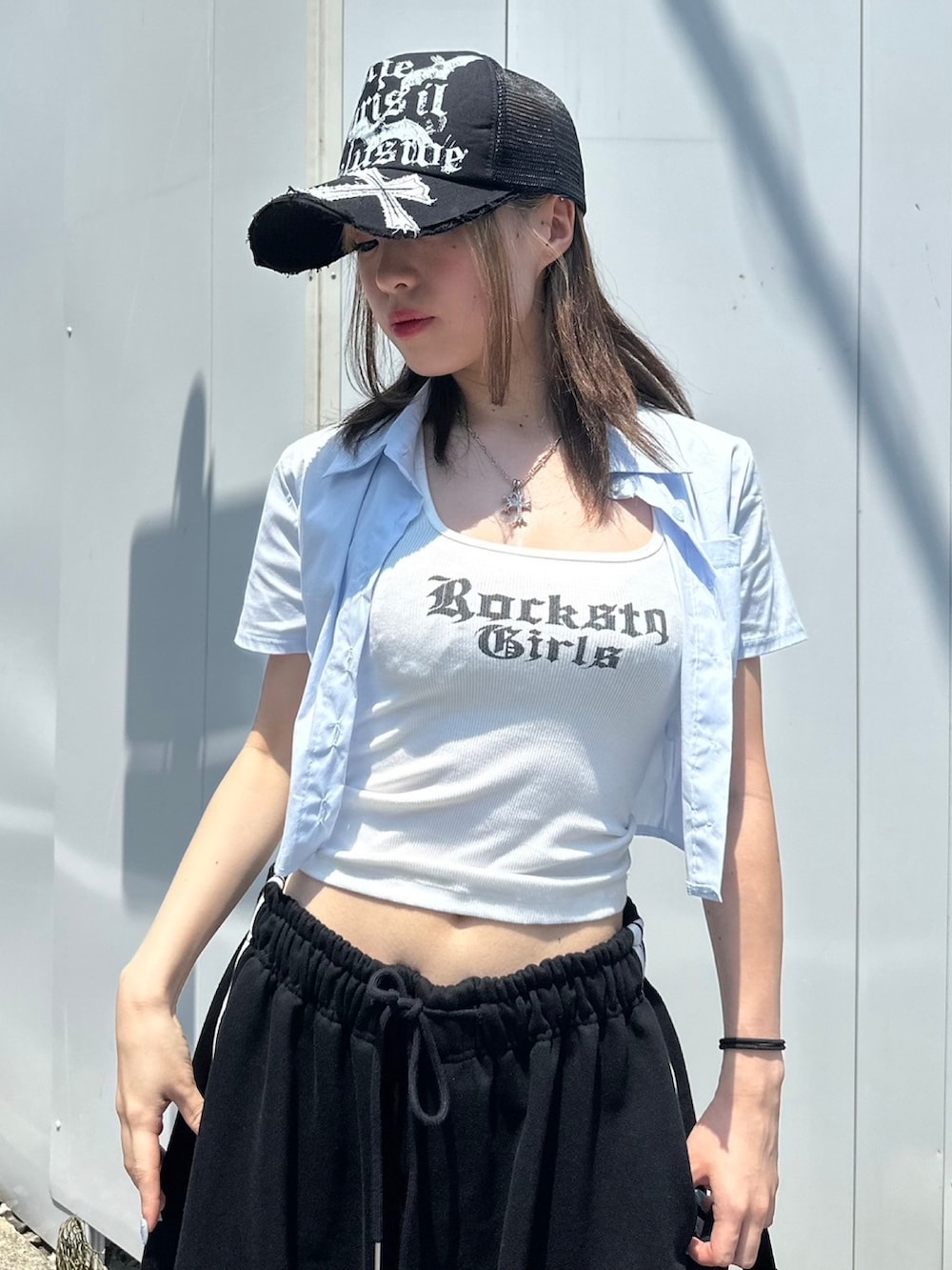 ホワイト系のタンクトップ、ブラック系のショルダーバッグ、ブラック系のスニーカーを着用したレディースの夏コーディネートの2枚目の写真