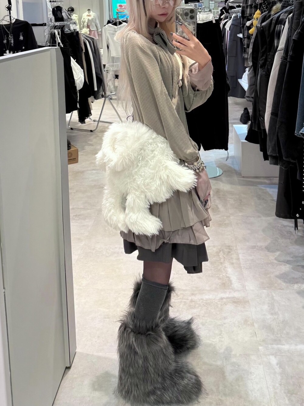 ホワイト系のショルダーバッグ、グレー系のブーツを着用したレディースの秋コーディネートの2枚目の写真