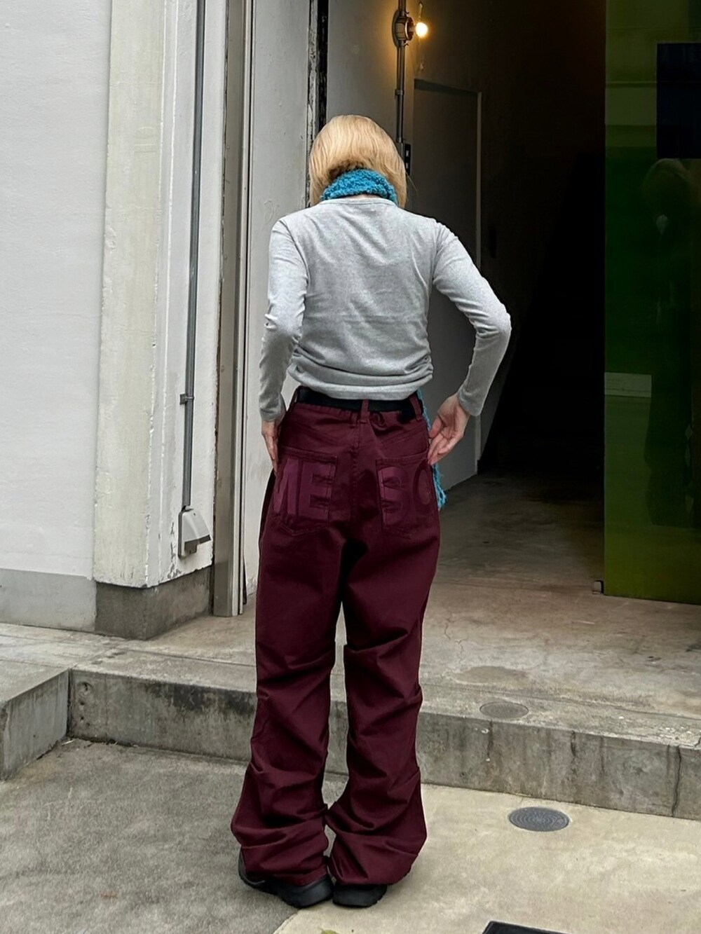 レッド系のデニムパンツを着用したレディースの秋コーディネートの2枚目の写真