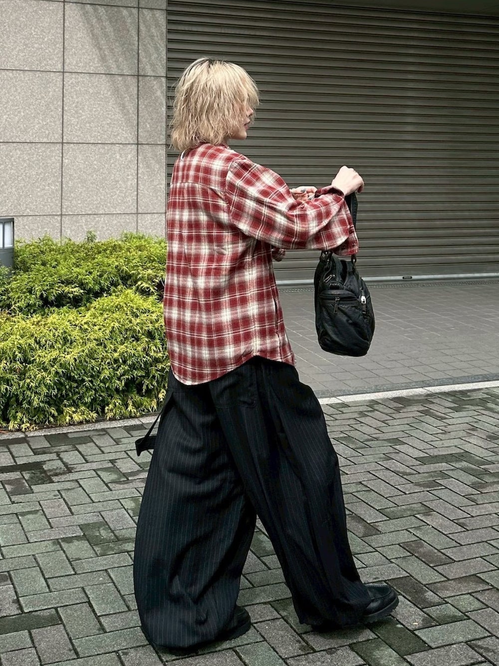 ブラック系のタンクトップ、ブラック系のトートバッグ、ブラック系のスラックスを着用したレディースの冬コーディネートの4枚目の写真