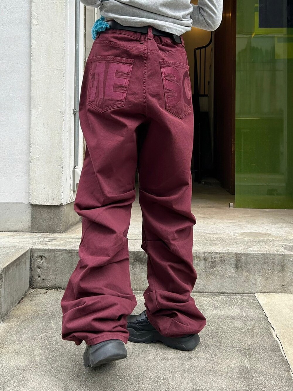 レッド系のデニムパンツを着用したレディースの秋コーディネートの5枚目の写真