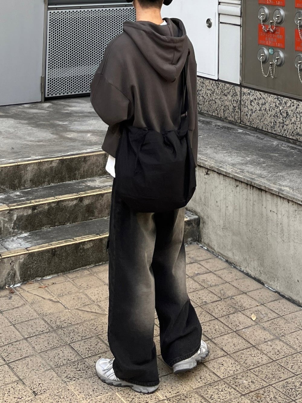 グレー系のパーカー、ブラック系のデニムパンツを着用したメンズの冬コーディネートの2枚目の写真