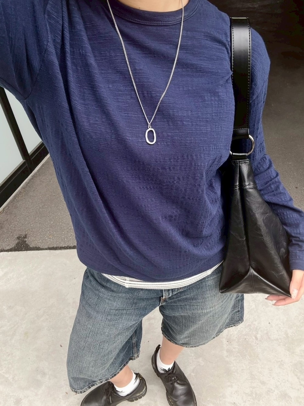 ブラック系のショルダーバッグ、ホワイト系のタンクトップ、ブルー系のTシャツ/カットソーを着用したレディースの夏コーディネートの4枚目の写真
