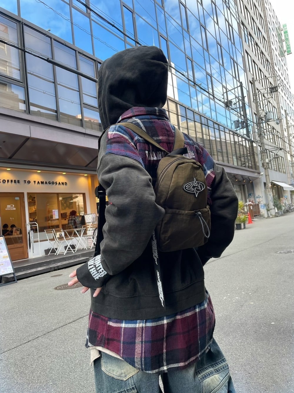 グリーン系のバックパック/リュック、グレー系のTシャツ/カットソー、ブルー系のデニムパンツを着用したレディースの冬コーディネートの2枚目の写真