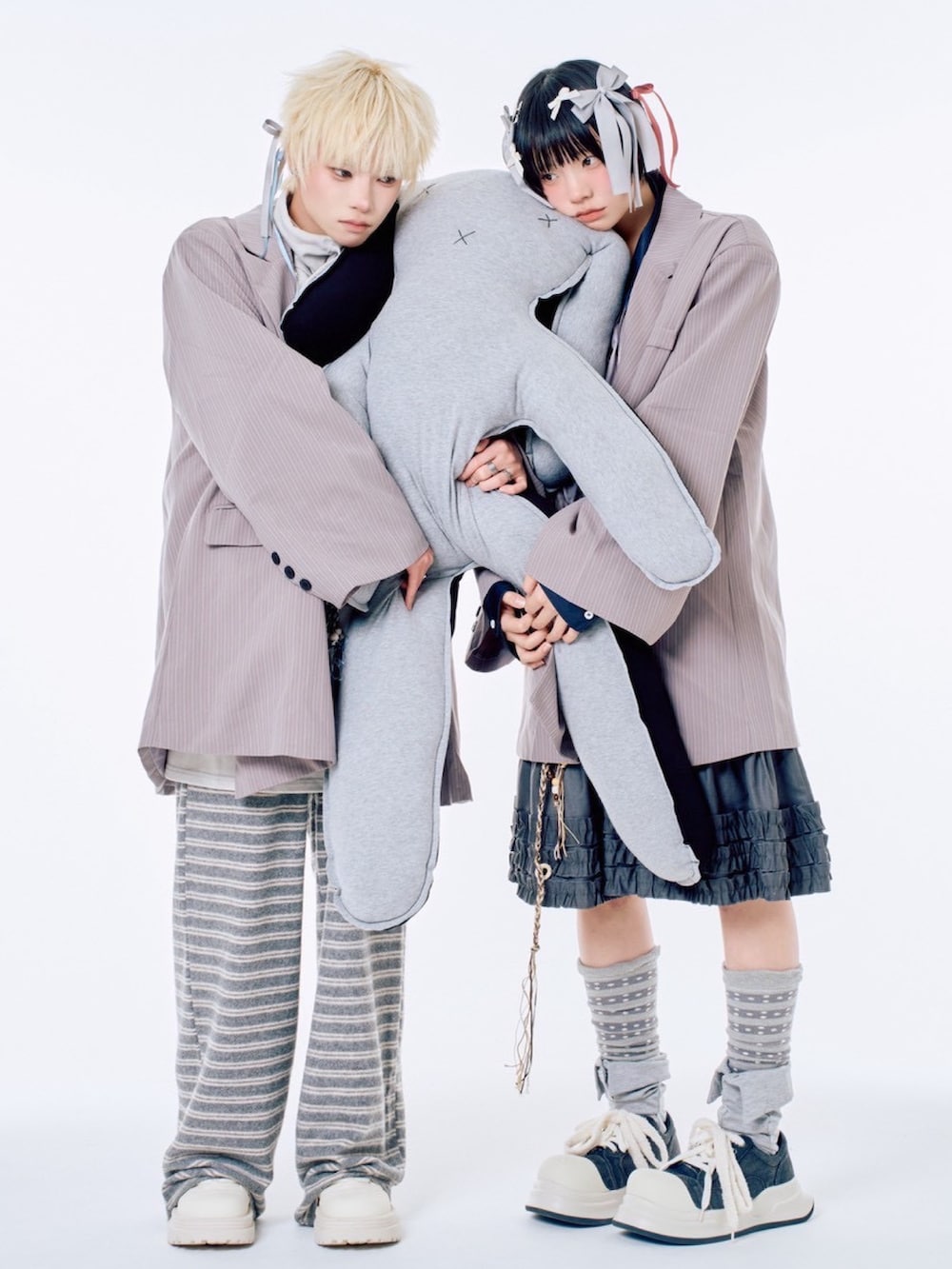 グレー系のスウェットパンツ、ブラック系のスカート、グレー系のテーラードジャケットを着用したレディースの春コーディネートの3枚目の写真