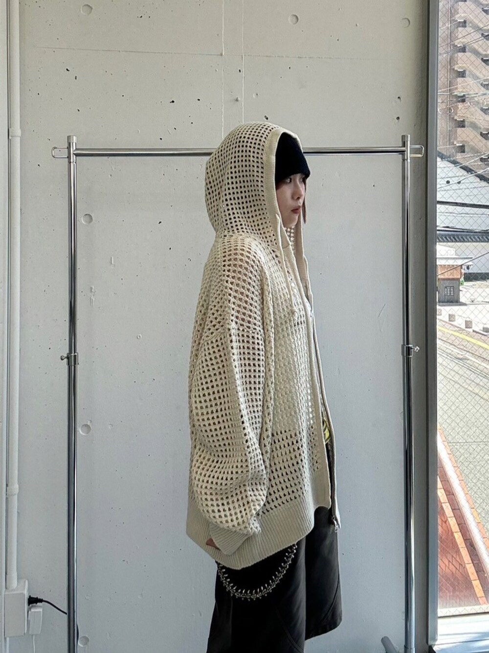 ホワイト系のパーカー、ブラック系のスニーカー、ホワイト系のタンクトップを着用したレディースの春コーディネートの4枚目の写真